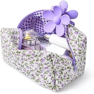 Detail of floral makeup bag featuring purple flower charm and plaid lining