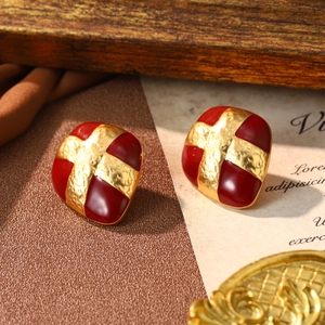 Macro detail of red enamel and gold hammered texture on French vintage square earrings