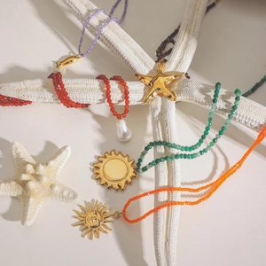 Detail of colorful beaded necklaces with gold sea star charms and baroque pearls