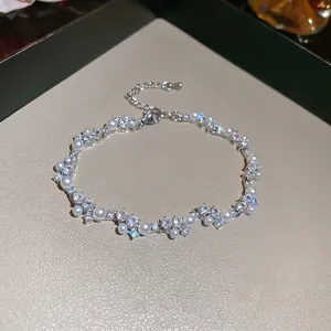 Elegant irregular silver bracelet featuring interlocking pearls and sparkling zircon stones