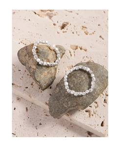 Detailed view of silver multifaceted beads ring and white pearl on natural stone