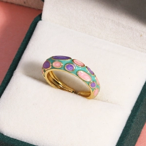 Vue macro d'une bague en émail de style chinois avec points colorés dans un écrin vert