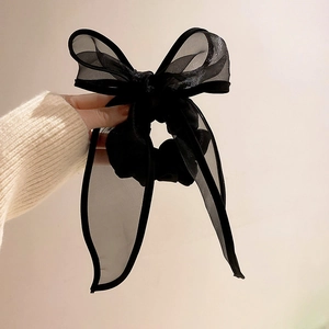 Détail d'une grande pince à cheveux en organza noir avec d'élégantes couches de tulle