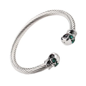 Silver stainless steel twisted C-shape cuff bracelet with green-eyed skull detail