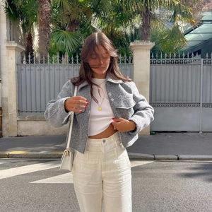Women gray textured zipper jacket with lapel collar styled with white trousers