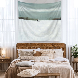 Detail showing an artistic winter landscape tapestry hanging on a cozy bedroom wall