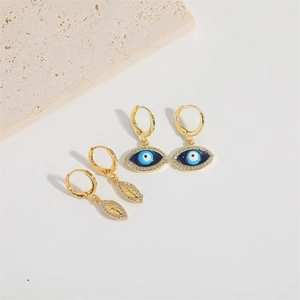Vista dettagliata degli orecchini dorati Evil Eye e Vergine Maria con zirconi micro-incastonati