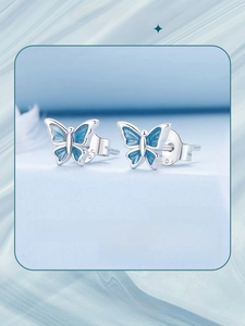 Detail of S925 sterling silver butterfly studs with blue enamel and engraved logo