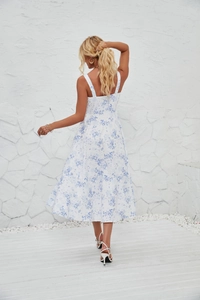 Rear view of white and blue floral midi dress featuring a slim fit back and flared hem