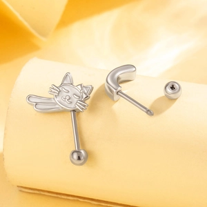 Silver titanium cat ear stud with long tail design on warm minimalist paper background