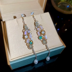 Detail of vintage gold tassel earrings with colorful crystals and white pearls in box