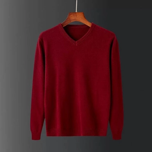Nahaufnahme von weinrotem V-Ausschnitt Strickpullover mit feiner Wollstruktur auf Holzbügel