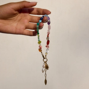 Detailed shot of multi-color natural stone beaded bracelet with golden sun charms