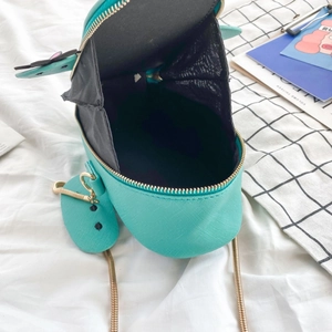 Close-up of blue cartoon crossbody bag showing spacious black interior and gold chain