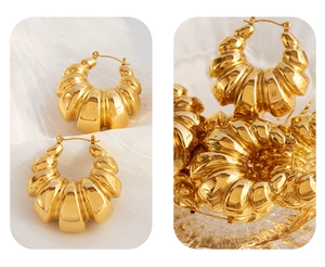 Macro detail of gold-plated croissant hoop earrings with ribbed geometric texture