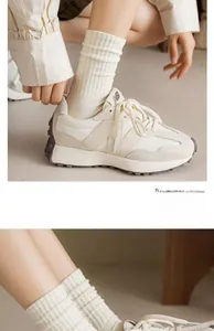 Close-up of cream retro sneakers with grey suede panels and ribbed cotton socks