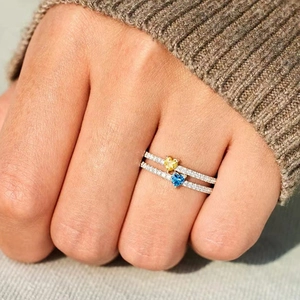 Anelli a cuore sovrapposti con gemme gialle e blu e fasce con pavé di diamanti