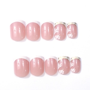 Détails d'ongles autocollants nude pink style French avec motifs floraux blancs et dorures