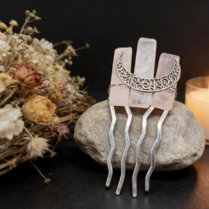 Detail view of handmade moon hair comb with natural pink crystal quartz on silver metal