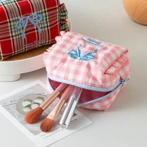 Plaid makeup bags with ruffles and blue bow embroidery in a lifestyle setting