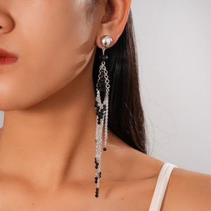 Detail view of long tassel earrings with silver chains and black faceted glass beads