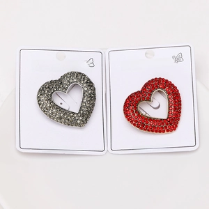 Detail of silver and gold heart brooches with rhinestones on a fashion display card