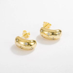 Detailed close-up of gold C-shaped stud earrings with sparkling star-set zircon stones