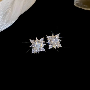Detailed view of snowflake zircon earring with square cut center on black background