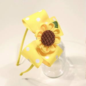 Detail of yellow sunflower headband with white polka dot ribbon bow for young girls