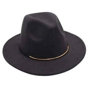 Détail d'un chapeau en laine noir avec un élégant ornement en métal doré incurvé
