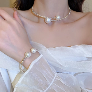 Detail shot of elegant silver open choker and matching pearl cuff bracelet on a model