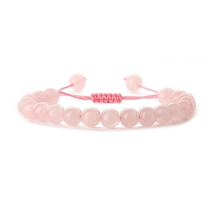 Pink quartz beaded bracelet with handmade woven adjustable rope on white background