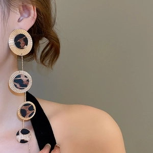 Detailed view of layered leopard print hoop earrings hanging gracefully on a model