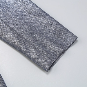 Close-up of silver sequined shirt cuff featuring shimmering metallic thread fabric