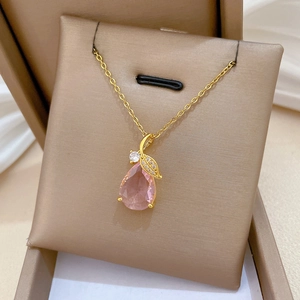 Détail du fermoir feuille dorée et du pendentif en cristal rose sur chaîne en or