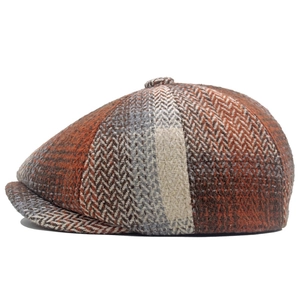 Detail of herringbone and plaid tweed fabric texture on a classic newsboy cap