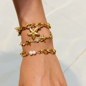 Detail shot of ocean-themed layered bracelets with starfish charm and pearl accents