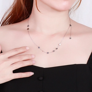 Minimalist silver pentagram choker necklace with nine stars shown on a female model