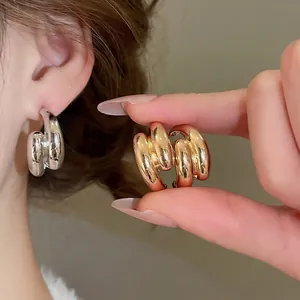 Fashionable C-shaped layered gold and silver hoop earrings in a minimalist metal design
