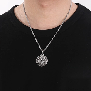 Detail of Viking star pendant with runes and turquoise eye on a male model