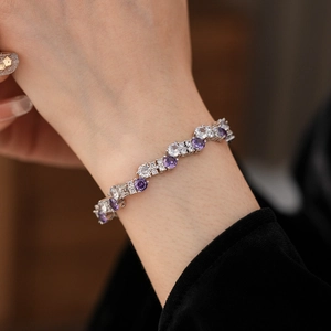 Close-up of elegant wavy bracelet with purple amethyst and white cubic zirconia stones