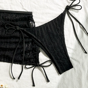 Detailansicht eines schwarzen Bikini-Sets aus Crinkle-Stoff mit seitlichen Bändern