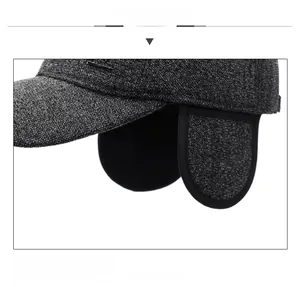 Detail of dark grey tweed winter baseball cap with earmuffs and thick warm texture