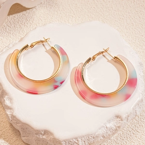 Macro detail of colorful acetate resin C-shaped hoop earrings with gold metal lining