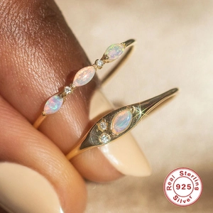 Macro shot of S925 sterling silver rings with marquise opal stones on a model hand