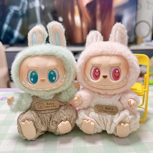 Close-up of Labubu plush doll outfits featuring green and pink knit hoodies and overalls