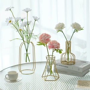 Three-piece set of gold geometric metal flower vases with glass tubes and faux daisies