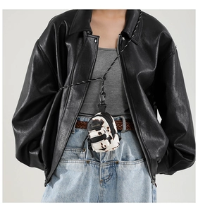 Close-up of mini cow print canvas pouch with black lanyard and fashion label detail