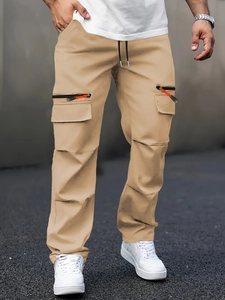 Detailed view of men's khaki cargo pants featuring multiple zipper pockets and straight cut