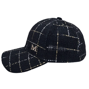 Close-up of black tweed baseball cap with metallic fiber weaving and M logo detail